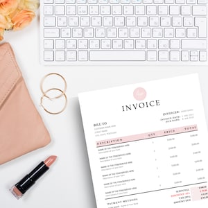 Invoice template laying next to nude purse, gold earrings and lipstick.