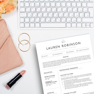 May include: A resume template for an elementary school teacher named Lauren Robinson, featuring a white keyboard, a pink quilted clutch, gold hoop earrings, a tube of pink lipstick, and a bouquet of peach roses on a white surface.