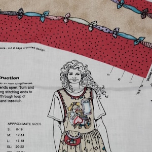 May include: A white fabric with red polka dots and a printed design of a woman wearing a brown and white apron with a pocket. The fabric includes instructions for making a creative clip construction with approximate sizes listed for small, medium, large, extra large, and extra extra large.