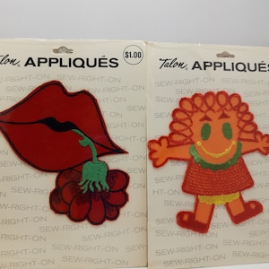 May include: Two iron-on patches on white cardstock packaging. The left patch is a red flower with a green stem and a red lip. The right patch is a smiling orange person with green hair and a red dress. The packaging says "Talon Appliques" and "Sew-Right-On".