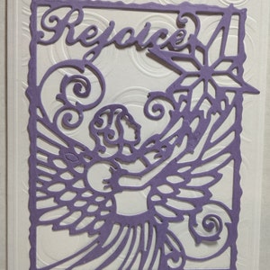 May include: A purple paper cut-out card with a decorative angel design and the word "Rejoice" in a script font.
