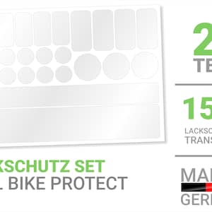 Könnte beinhalten: Ein Set mit 27 transparenten Schutzaufklebern für ein Fahrrad. Die Aufkleber bestehen aus 150µ transparenter Folie und sind dazu bestimmt, den Fahrradlack vor Kratzern und Absplitterungen zu schützen. Das Set enthält verschiedene Formen und Größen, darunter Rechtecke, Kreise und Ovale. Die Aufkleber sind mit "Lackschutzfolie Transparent" und "Made in Germany" beschriftet.