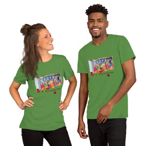 May include: Two people wearing green t-shirts with a graphic of a box of Dots candy. The box says "Dots" and "Be Creative and Stay Lit Studio".