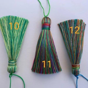 May include: Three colourful tassel ornaments with green, blue, red, yellow, and white stripes. The tassels are labelled 10, 11, and 12.