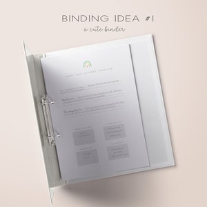 Op de afbeelding: Een witte binder met een regenboogontwerp en de tekst "BINDING IDEA #1 a cute binder" op de omslag. De binder is open op een pagina met de titel "ABOUT OUR JOURNEY TOGETHER" en verschillende secties om in te schrijven.