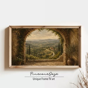 May include: A framed landscape painting depicting a Tuscan vista, viewed through an arched stone structure. The artwork features rolling hills, cypress trees, and a winding road. The frame is made of light-colored wood. The text "PineconeOoze Unique Frame TV art" is at the bottom.