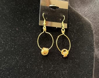 Hand shaped interlocking gold loops on hoop earrings