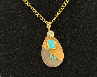 Resin and wood backdrop and turquoise color charm accented with blue beads necklace