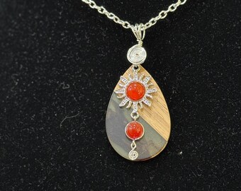 Sun and moon charms sit atop wood and resin backdrop necklace
