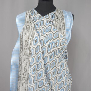 Puede incluir: Bufanda estampada sobre un maniqu&iacute;. La bufanda presenta un dise&ntilde;o geom&eacute;trico repetitivo en tonos azules, grises y blancos. El borde tiene rayas azules y blancas. La bufanda est&aacute; hecha de una tela ligera.