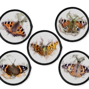 May include: Five round iron-on patches with watercolor illustrations of butterflies. The butterflies are in various shades of orange, brown, black, and white.
