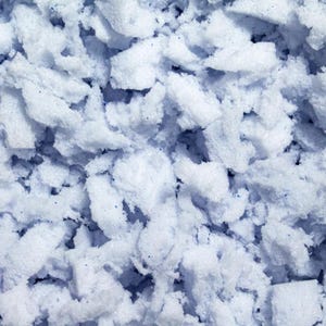 May include: Close-up of a blue and white shredded memory foam material. The foam is soft and fluffy, and it looks like it would be comfortable to sleep on.