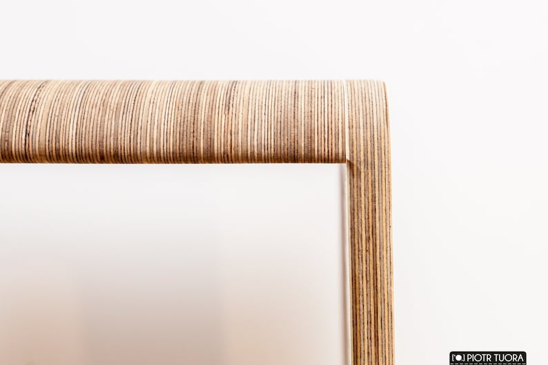 May include: Close-up of a wooden frame made of thin strips of plywood, creating a unique and modern design.