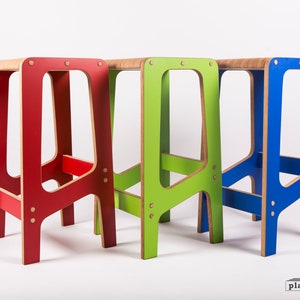 May include: Three wooden step stools in red, green, and blue. The stools are made of plywood and have a simple, modern design.  The stools are all the same size and shape, but they are painted in different colours.  The stools are arranged in a row, with the red stool on the left, the green stool in the middle, and the blue stool on the right.  The stools are all standing on a white surface.  The text "playwoodworks" is visible in the bottom right corner of the image.
