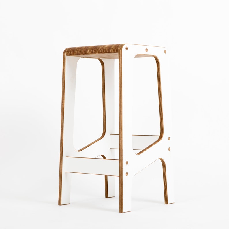 May include: White wooden stool with a simple, modern design. The stool has a rectangular seat and four legs.