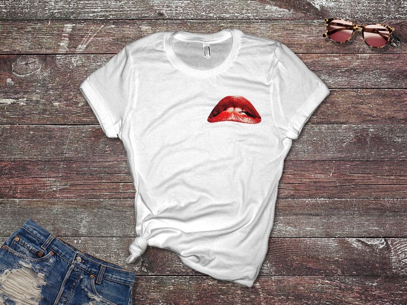 Peut inclure: T-shirt blanc avec un imprim&eacute; graphique de l&egrave;vres rouges et blanches.