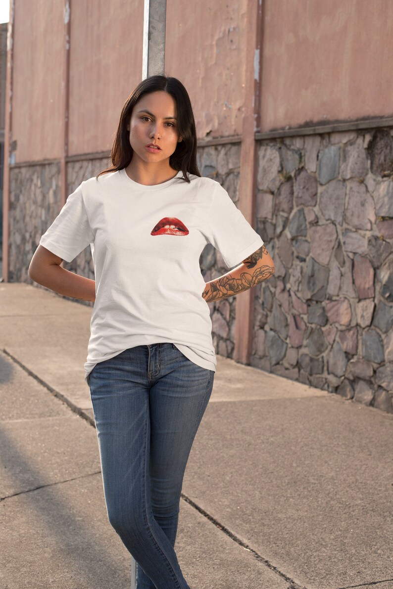 Peut inclure: Un t-shirt blanc avec un motif rouge et blanc de l&egrave;vres sur le devant.