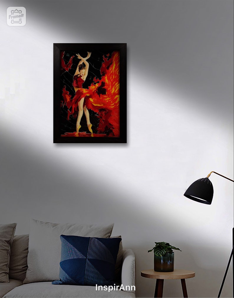 May include: A framed painting of a woman in a red dress with a flowing skirt, dancing against a black background with orange and yellow accents. The painting is in a black frame.