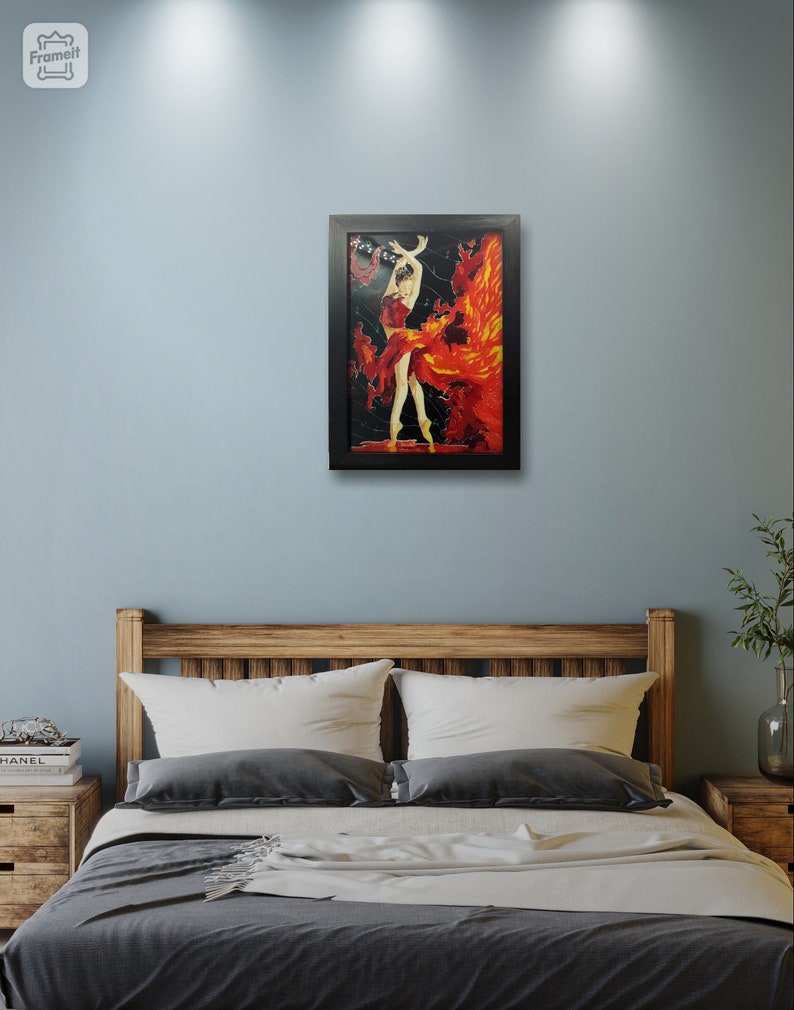 May include: A framed painting of a woman in a red dress with a fiery background. The painting is hanging on a light blue wall above a bed with a wooden headboard.