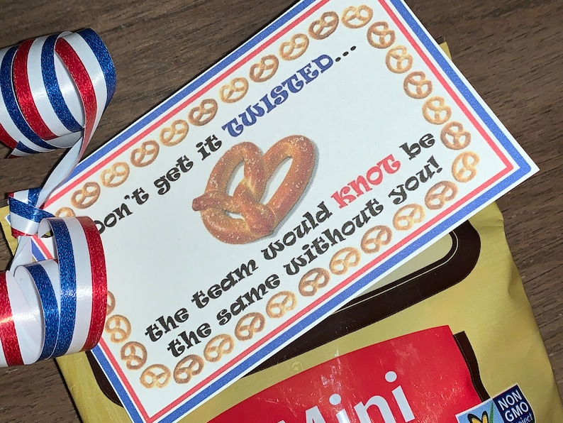 May include: A white card with red and blue borders and a pretzel image. The card reads "Don't get it twisted... the team would knot be the same without you!"