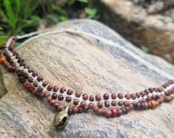 Collana unica con perline di legno e campanellino in ottone