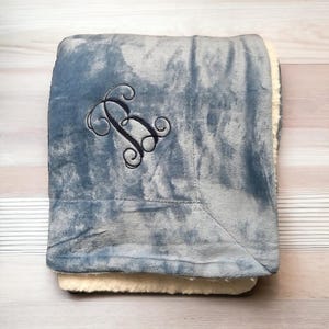 May include: A soft, gray and white fleece throw blanket with a black embroidered letter "B" in a decorative script font.