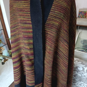 May include: A striped shawl with a black border and fringe. The shawl is made of a soft, warm fabric and is perfect for keeping you warm in the winter.