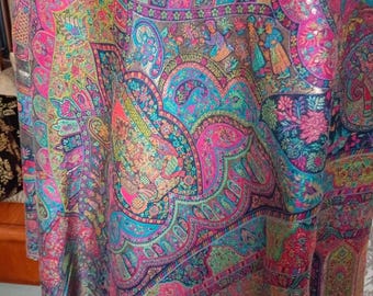 May include: A brown shawl featuring a vibrant, multi-colored paisley pattern with intricate floral motifs and small human figures. The design incorporates bright shades of pink, turquoise, blue, and green, creating a dense, ornate, and detailed tapestry-like appearance across the fabric surface.