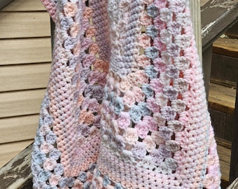 Pastel crochet baby blanket/lapghan in pastel pinks, peach, lavender and white.
