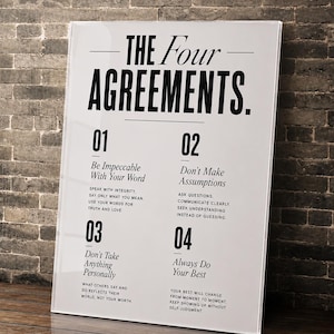 May include: A rectangular white wall art print featuring the black text The Four Agreements. It lists four numbered principles: Be Impeccable With Your Word, Don't Make Assumptions, Don't Take Anything Personally, and Always Do Your Best, with subtext.