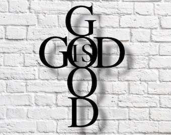 May include: Black metal cross wall decor with the words "God is Good" spelled out in a unique design.