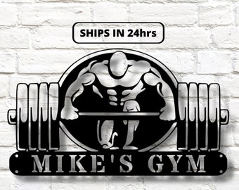 May include: Black metal sign featuring a silhouette of a weightlifter lifting a barbell. The sign reads "MIKE'S GYM" in a decorative font.