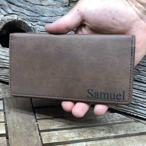 May include: A brown leather checkbook cover with the name "Samuel" embossed in black.
