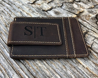 May include: A brown leather wallet with a money clip and a stitched monogram of "S|T".