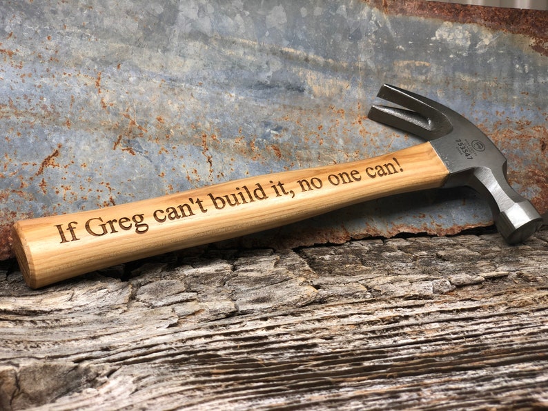 May include: A wooden-handled hammer with a metal head. The handle is engraved with the text "If Greg can't build it, no one can!"