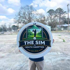 Pu&ograve; includere: Un cartello circolare con la grafica di un golfista su un green, una pallina da golf e una luce da proiettore. Il testo recita THE SIM IN SOUTH HAMPTON Est. 2026. Il design utilizza colori nero, verde, bianco e arancione su sfondo bianco.