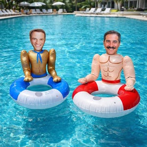 May include: Two inflatable pool floats shaped like muscular men with smiling faces. One float has a gold torso and a blue and white inner tube. The other has a tan torso and a red and white inner tube. Both are floating in a blue pool.