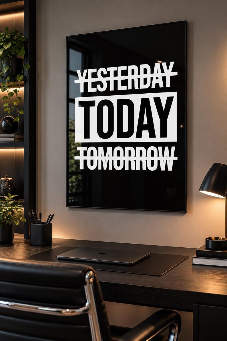 May include: A rectangular wall art piece featuring a black background with white text that reads YESTERDAY with a line through it, TODAY in a large white box, and TOMORROW with a line through it. The print is framed in a thin black frame.