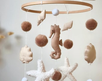 Dekoratives Mobile mit Muscheln und Seepferdchen, perfekt als Geschenk zur Babyparty, beige und braun.