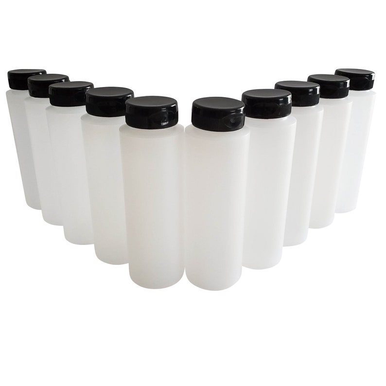 May include: Ten white plastic bottles with black screw-on lids. The bottles are arranged in a semi-circle.