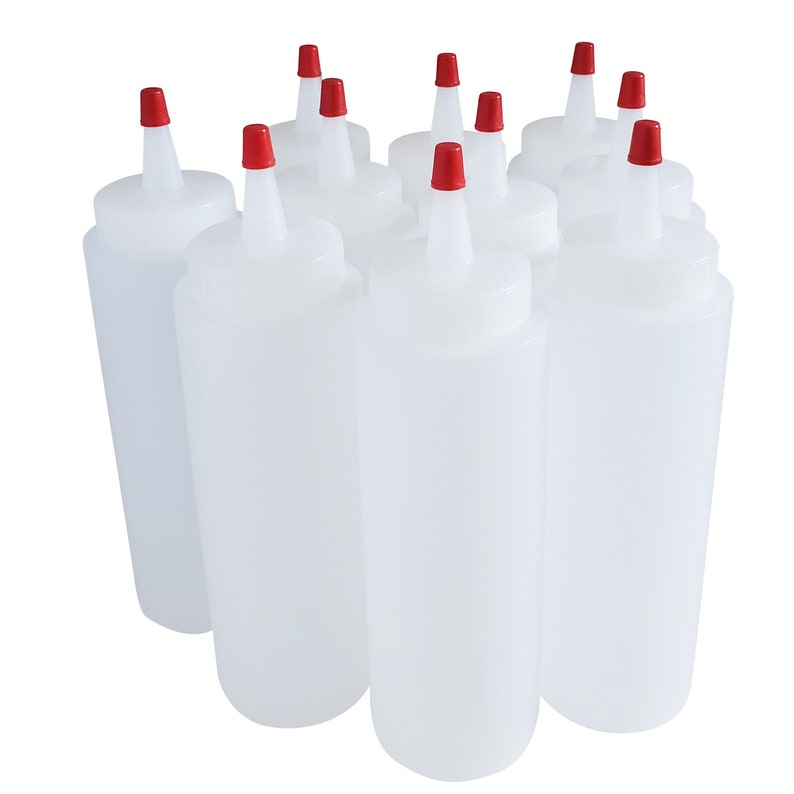 May include: Eight clear plastic squeeze bottles with red caps. The bottles are all the same size and shape, and they are arranged in a row.