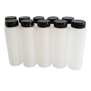 May include: Ten white plastic bottles with black screw-on lids. The bottles are all the same size and shape.