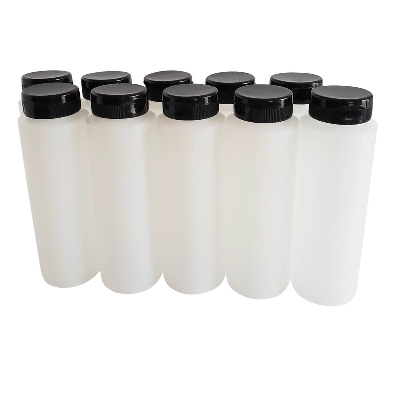May include: Ten white plastic bottles with black screw-on lids. The bottles are all the same size and shape.