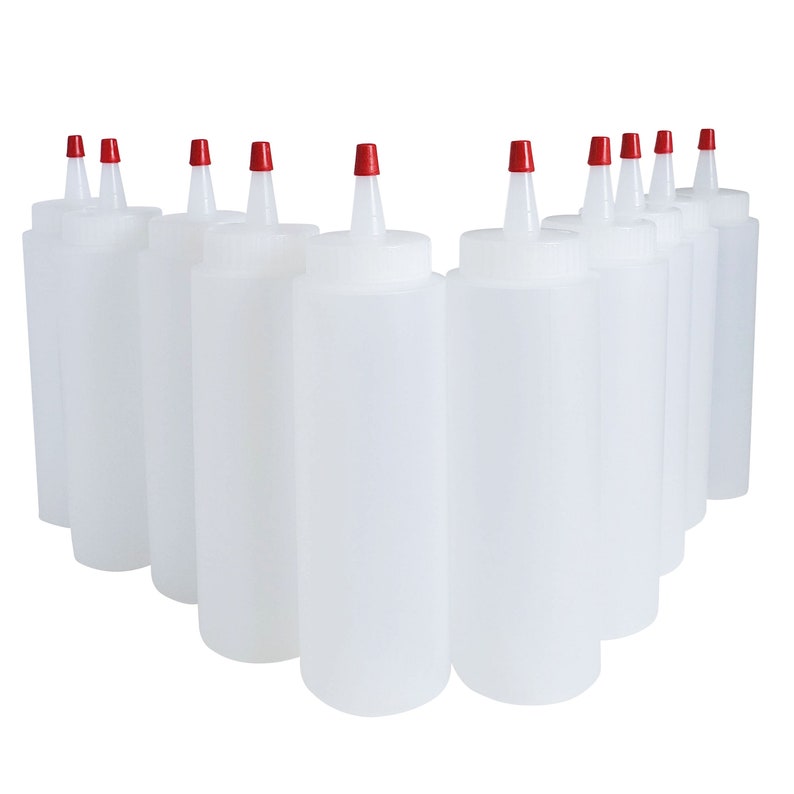 May include: Ten clear plastic squeeze bottles with red caps. The bottles are arranged in a semi-circle shape.