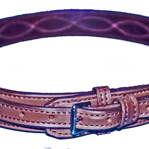 May include: A brown leather belt with a buckle and stitching detail. The belt is designed for equestrian use.