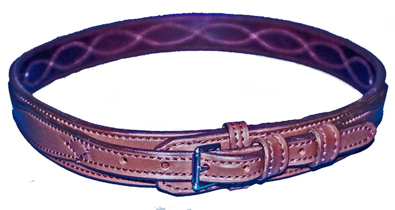 May include: A brown leather belt with a buckle and stitching detail. The belt is designed for equestrian use.