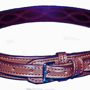 May include: A brown leather belt with a decorative stitching pattern and a silver buckle.