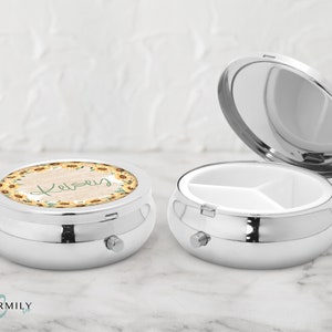 Peut inclure: Une boîte à pilules en argent avec un motif de tournesol et le nom "Kelsey" sur le couvercle. La boîte comporte trois compartiments à l'intérieur.