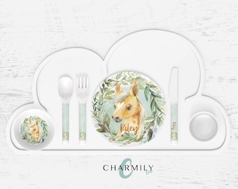 May include: A white cloud-shaped silicone placemat with a divided section for a plate, bowl, and cup. The placemat includes a matching spoon, fork, and knife with a green and white design. The plate features a watercolor illustration of a foal with the name "Riley" written below. The placemat is branded with "CHARMILY Kids."