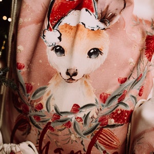 May include: A pink Christmas sack with a white drawstring. The sack features a watercolor illustration of a kangaroo wearing a Santa hat, surrounded by red and green flowers.